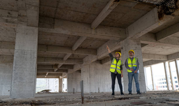 istock Male and female civil engineers working on construction site 1392568245