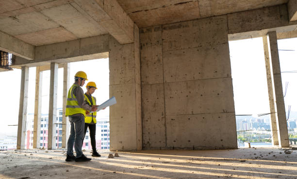 istock Male and female civil engineers working on construction site 1392568320