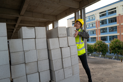 A female construction worker works on a construction site