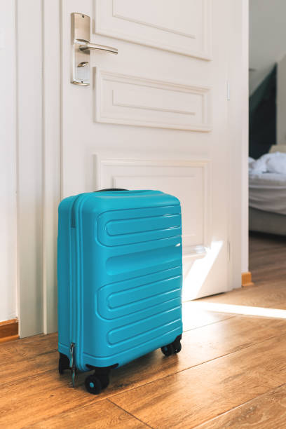 istock Blue travel suitcase in hotel apartment 1392569360