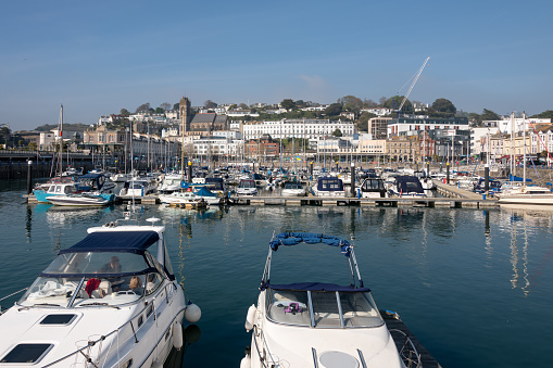 Torquay, UK. Saturday 16 April 2022. A view into Torquay town from the harbour with moored boats