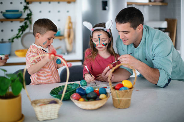 istock Family painting Easter eggs together. 1392570044