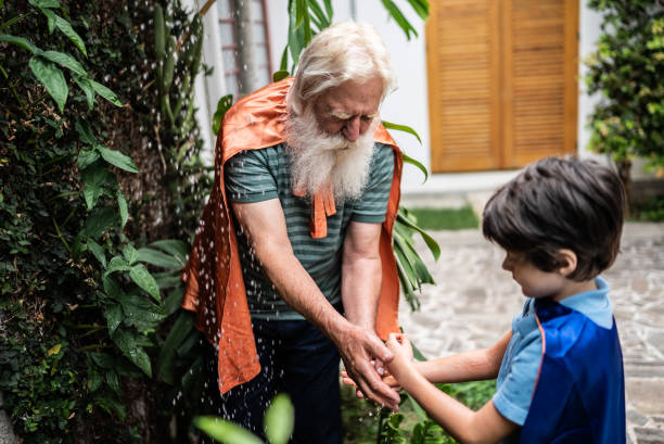 Senior man helping grandson cleaning arms