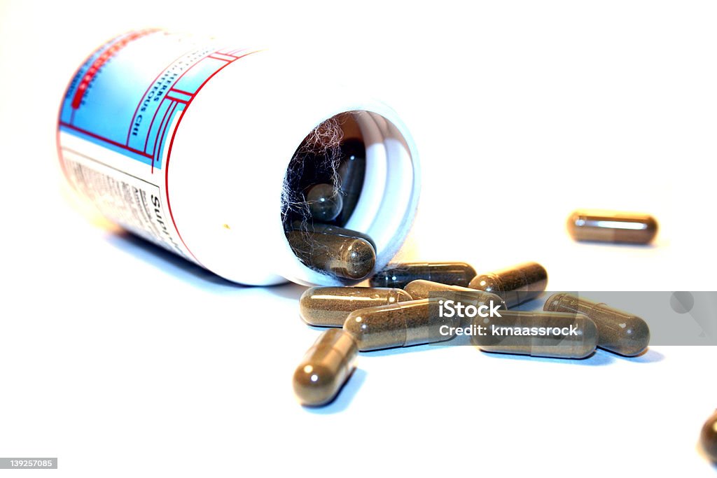 Bottle of Herbal Medicine Herbal medicine, focus on the pill coming out of the bottle. Canister Stock Photo