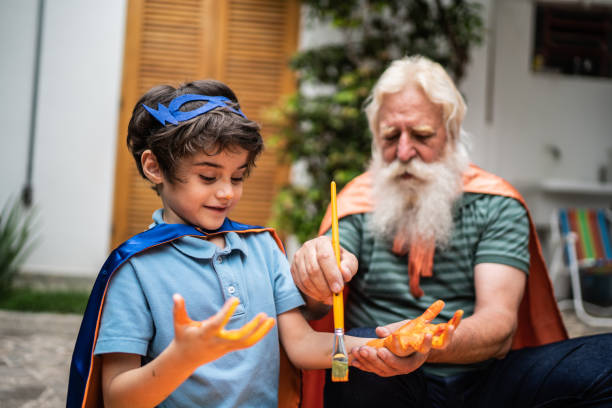 istock Grandfather painting grandson's hands 1392571456