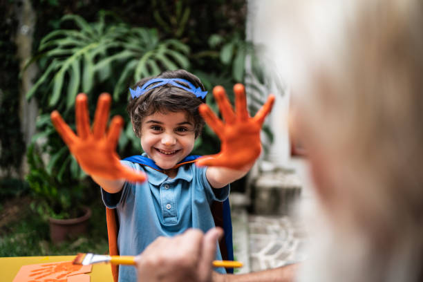 Happy cute boy showing hands with paint