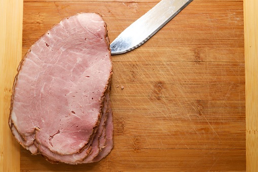 Sliced maple ham sitting on a wooden cutting board