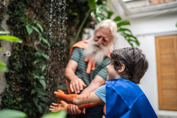 Senior man helping grandson cleaning arms