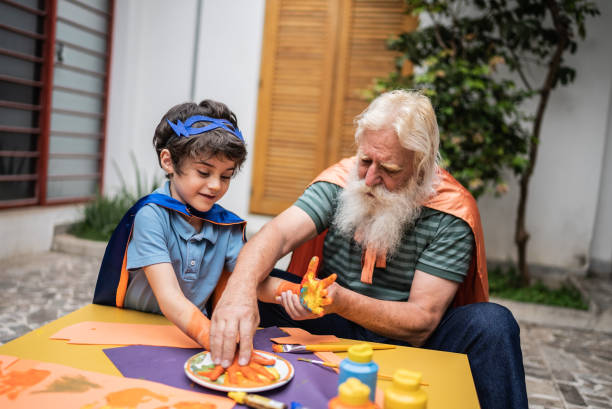istock Grandfather painting grandson's hands 1392571608