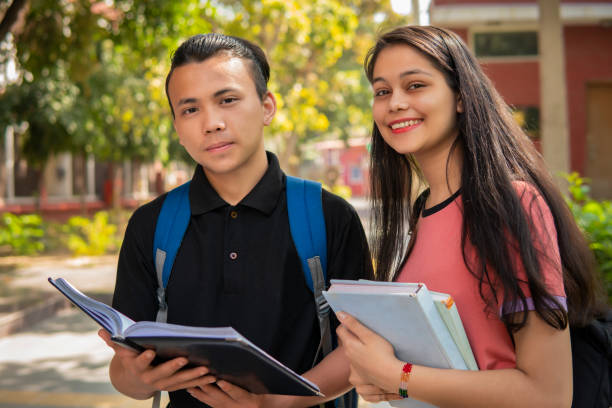 istock College student from different ethnicity holding books and looking at the camera. 1392571762