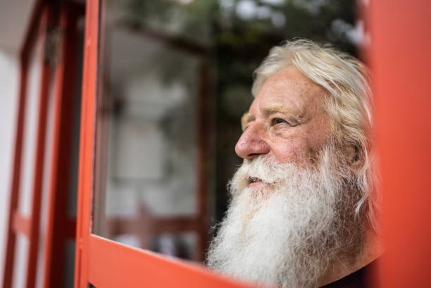istock Senior man looking away contemplating at home 1392571779