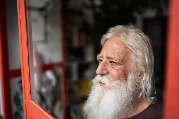 istock Senior man looking away contemplating at home 1392571785