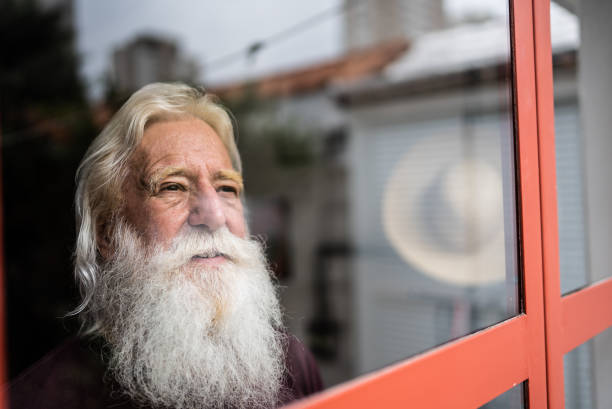 istock Senior man looking away contemplating at home 1392571810