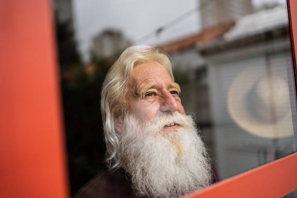 istock Senior man looking away contemplating at home 1392571850