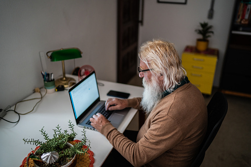 Senior man using laptop at home