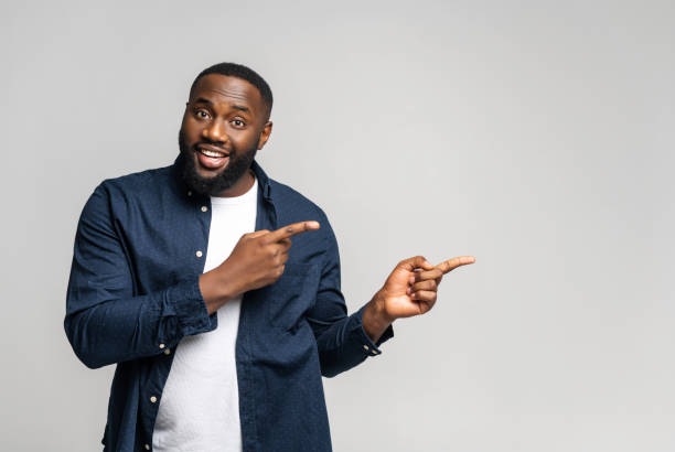istock African-American 30s guy point finger aside at the empty copy space 1392577152