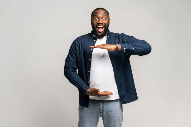istock Surprised African man holding hands in front of him, presenting something 1392578596