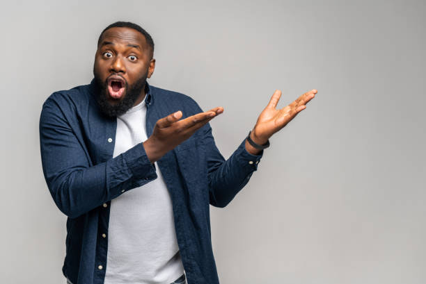 istock Just look here. Shocked African man points fingers of both hands away 1392578720