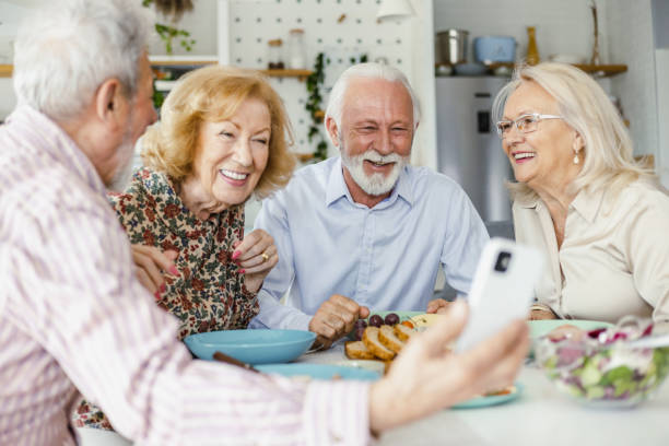 istock Senior group of friends using mobile phone during lunch 1392578807