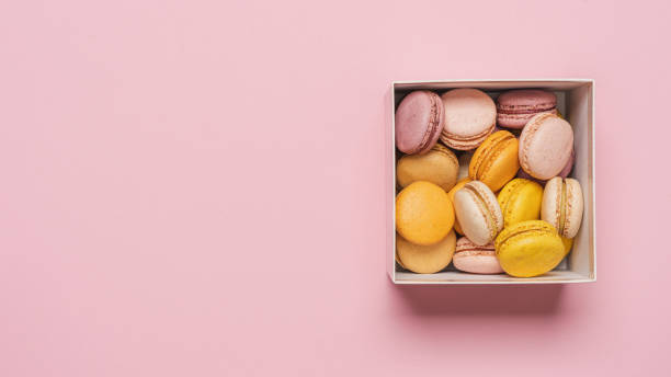istock Macaroons almond biscuits in  gift box on pink pastel background 1392578932