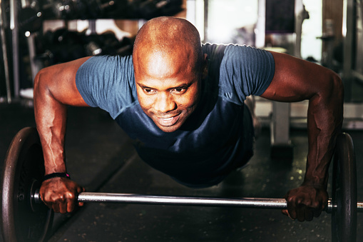 Black Man Doing Pushups With A Weight Bar Stock Photo - Download Image ...