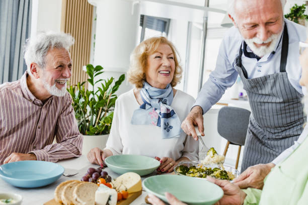 istock Senior man with an apron serves guests at the table 1392579124