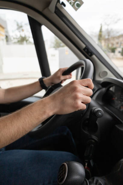 istock Two arms of a man driving a van wheel 1392582085