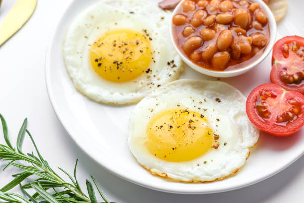 istock English breakfast with fried eggs, bacon, beans, tomatoes, spices and herbs 1392582976