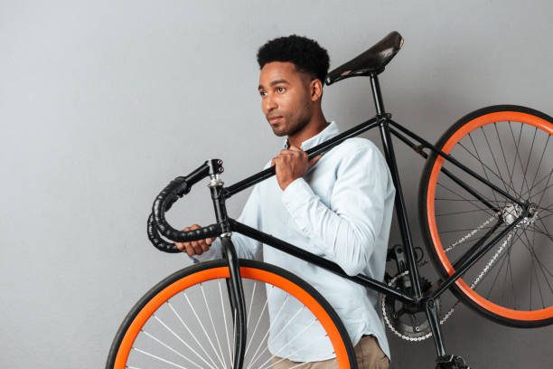 istock Young afro american man carrying bicycle 1392583032