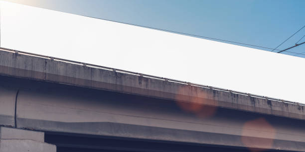 istock Long empty white banner fixed on concrete bridge at city street 1392583387