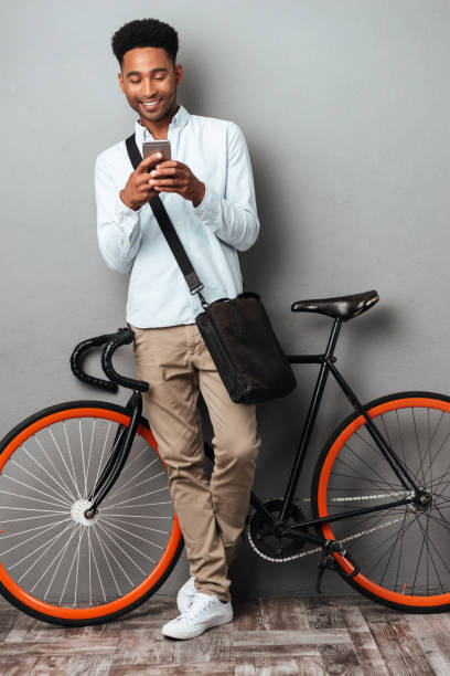 istock African man standing near bicycle chatting by phone. 1392584407