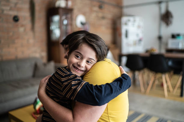 istock Mother carrying and embracing son at home 1392585099