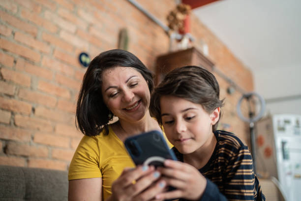 istock Mother and son using smartphone together at home 1392585258