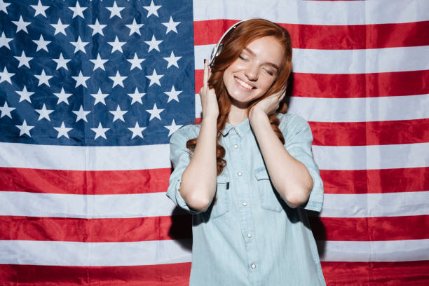 istock Happy redhead young lady listening music 1392587713