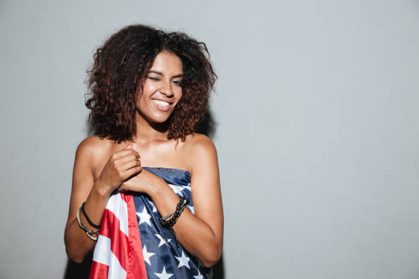 istock Amazing african young lady standing dressed in USA flag 1392587771