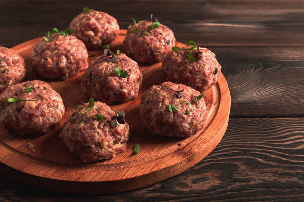 istock Raw meatballs, with micro greenery, on a cutting board, homemade, rustic, no people, 1392587977