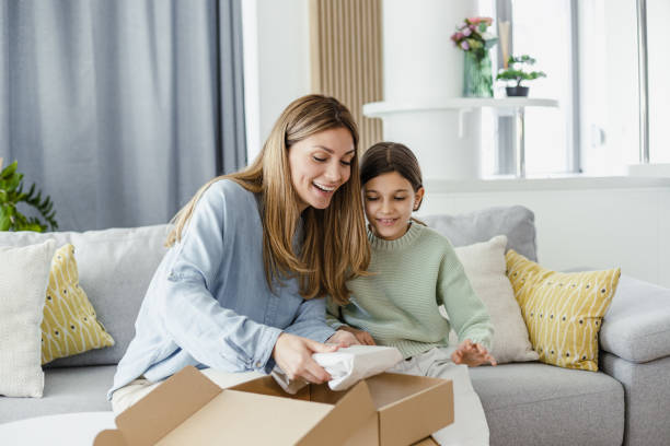 istock Smiling mother and daughter opening a delivery box 1392588538
