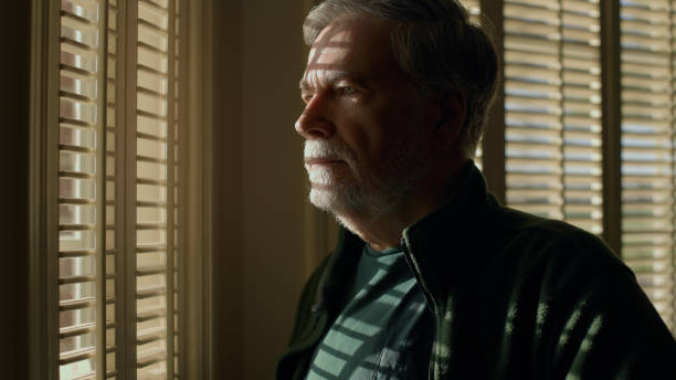 istock closeup senior man thinking  standing next to a window 1392588763