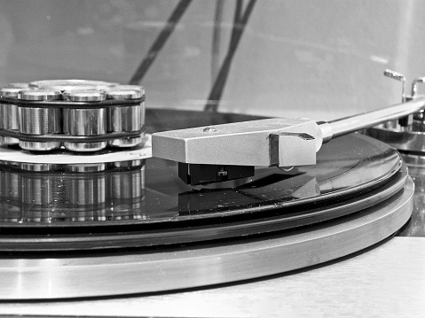 Close Up Of Gramophone Handle Showing Needle On Vinyl LP with - Vinyl Record Weight LP Stabilizer.