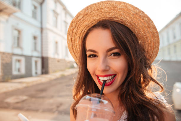 istock Happy young woman outdoors drinking juice 1392589097