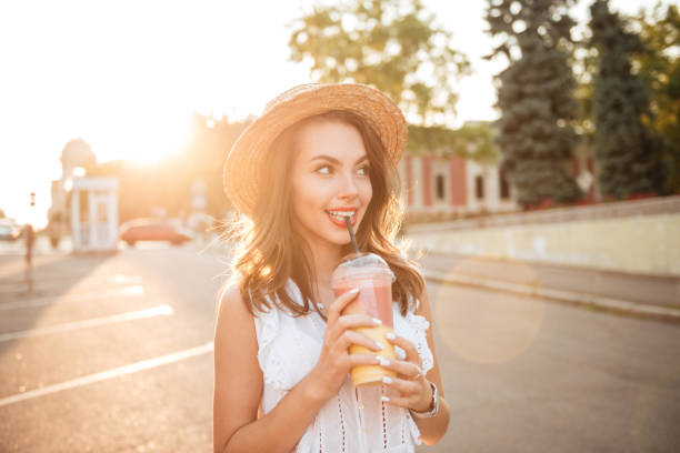istock Beautiful young woman outdoors drinking juice 1392589372