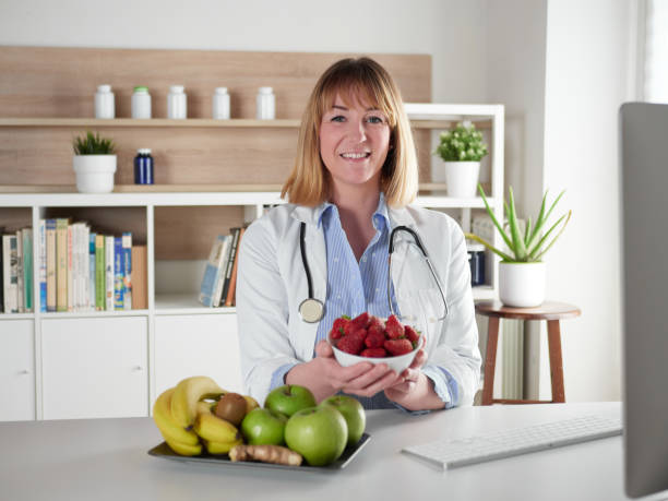istock Female nutritionist holding a strawberries fruit in office studio 1392591884