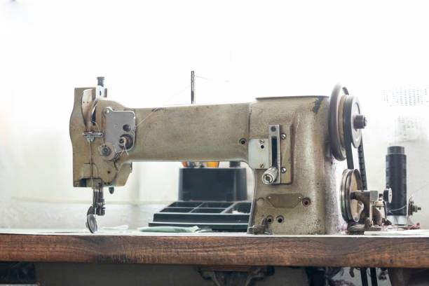 istock Old sewing machine on a table with a window in the background 1392592431