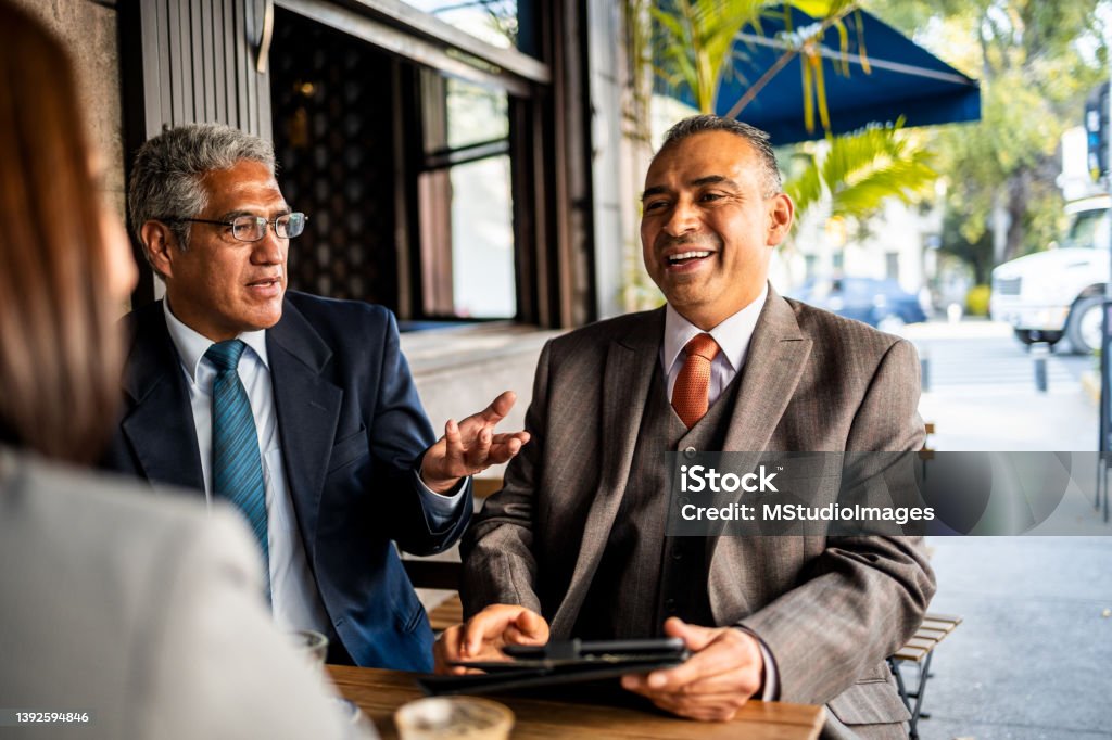 Business people sitting at restaurant Three business people sitting and talking Meeting Stock Photo