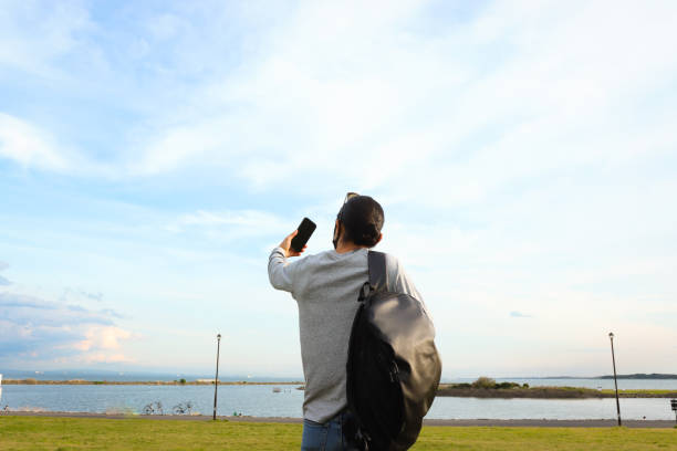 istock Young man enjoy taking selfies while traveling 1392595562