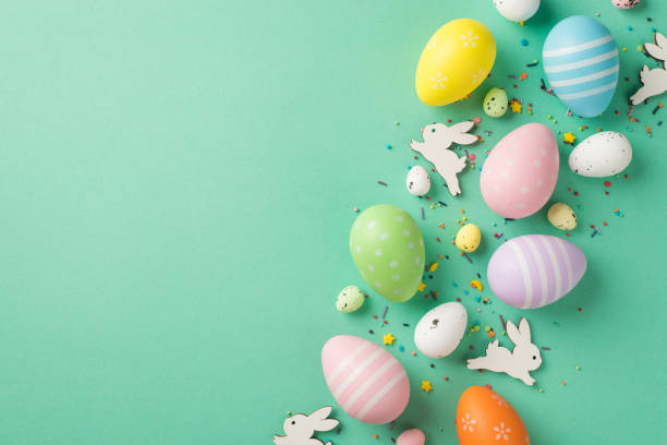 istock Top view photo of easter decorations multicolored easter eggs bunnies and confectionery topping on isolated turquoise background with empty space 1392598700