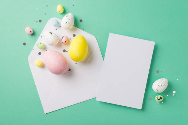 istock Top view photo of easter decorations white open envelope with confetti multicolored easter eggs and letter on isolated teal background with empty space 1392598941