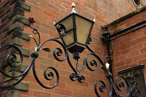 Old decorative metal lamp in English city.  Carlisle, England.