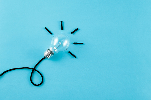 Innovation concept with light bulb, ropes and business related words on blue background