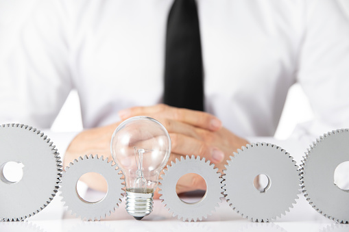 Business and finding solution concept with businessman and metal gear and lightbulb